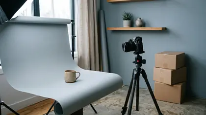 Kútik na fotenie produktov: hrnček na sivom papierovom pozadí, fotoaparát na statíve a kartónové krabice pri stene